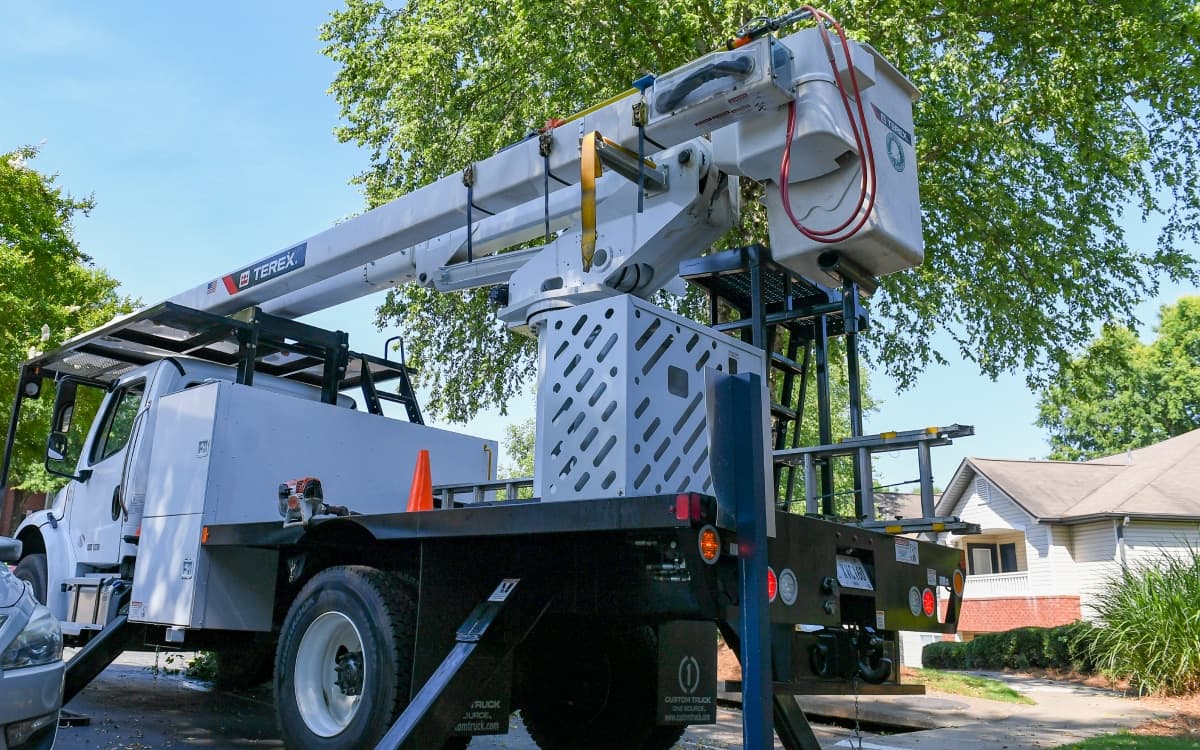 Bucket truck positioned for commercial tree maintenance