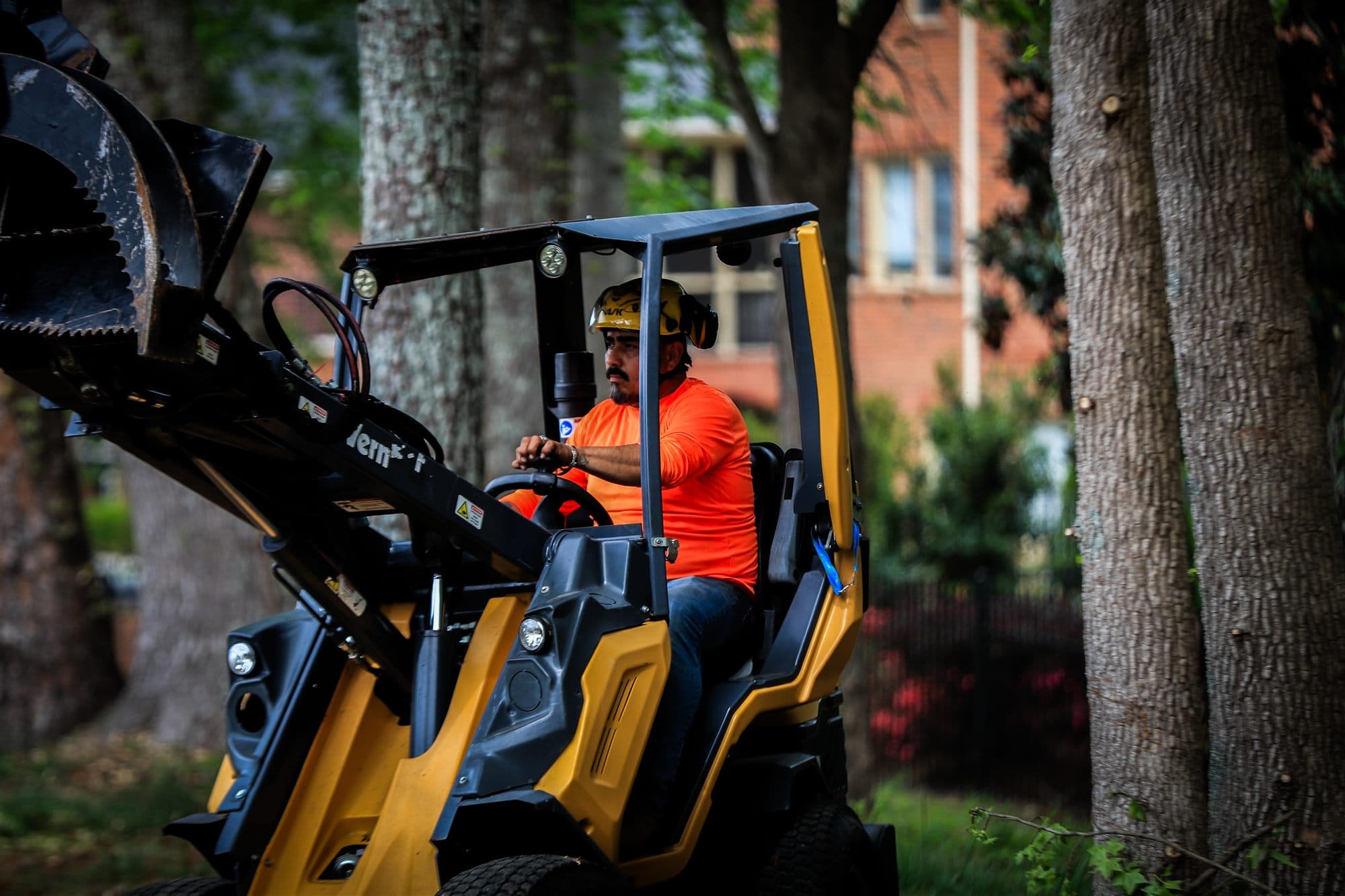 Compact loader with grapple attachment used on commercial property tree work